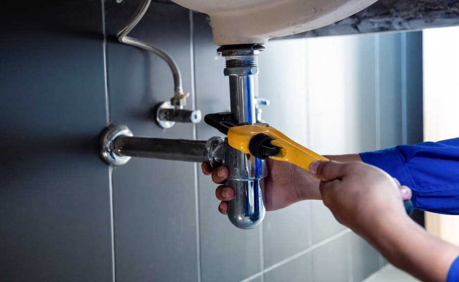 Vrouw belt loodgieter tijdens waterlekkage spoedgeval